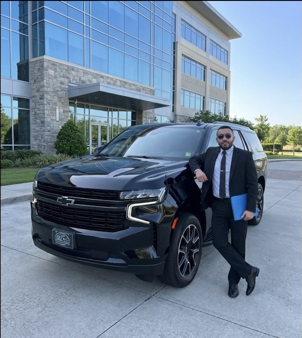 Owner of MLT Orlando Transportation standing beside black SUV